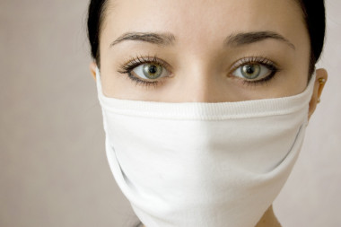 美麗的女人在醫(yī)療面具的臉圖片