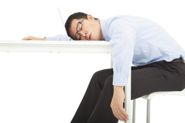 疲勞過度勞累的商人睡在桌子上