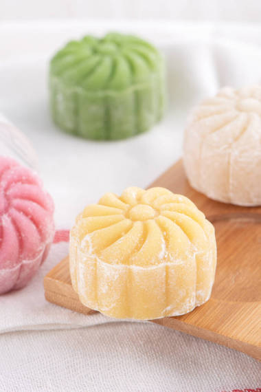 五彩斑斕的雪皮月餅，甜雪白的月餅，傳統(tǒng)的中秋節(jié)甜點(diǎn)色彩艷麗的木制背景，特寫，生活方式