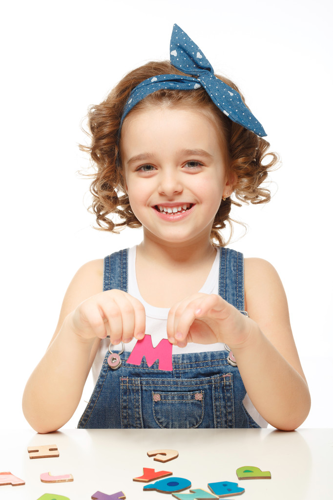 小女孩在玩在字母表中。显示字母 m 小女孩在玩在字母表中。显示字母 m