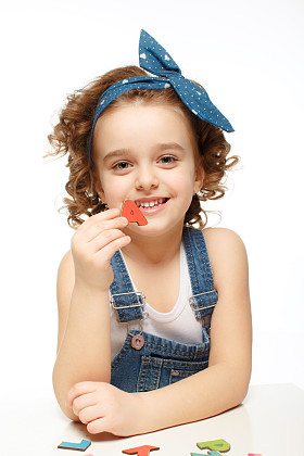 小女孩在玩在字母表中。显示这封信