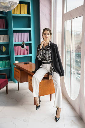 美丽的年轻女子在图书馆室内摆姿势穿着休闲装的黑发美人的肖像