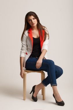 年輕漂亮的女孩構(gòu)成在工作室里。廣告的衣服