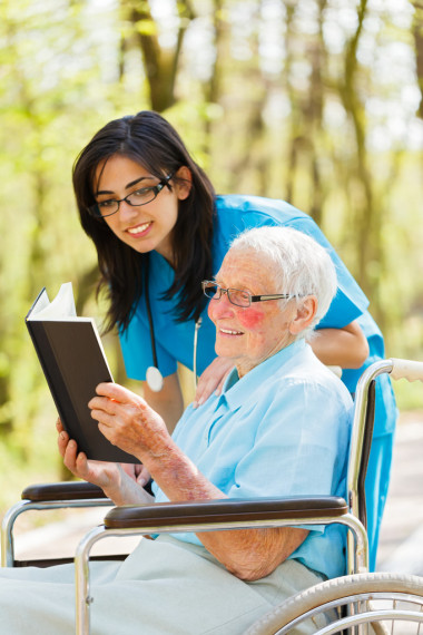 在轮椅上阅读的老太太图片