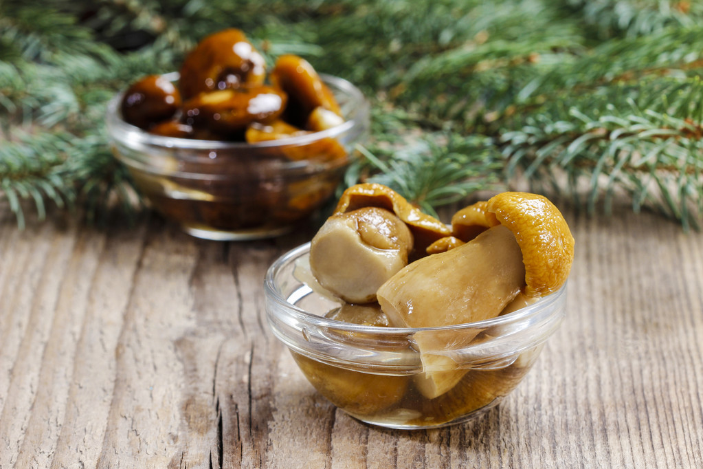 在透明的玻璃碗里腌制的蘑菇图片