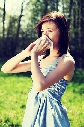 过敏的年轻女子在擦她的鼻子