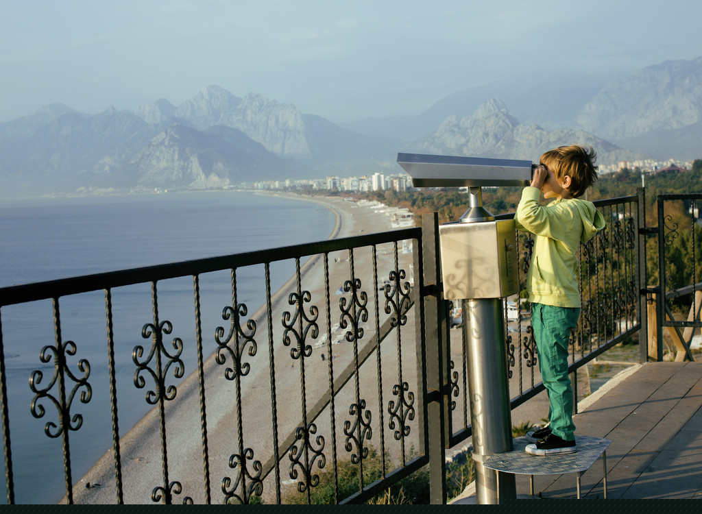 小可爱的男孩,通过望远镜观察海上 小可爱的男孩,通过望远镜观察海上