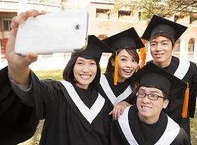群用手机拍照的大学毕业生图片