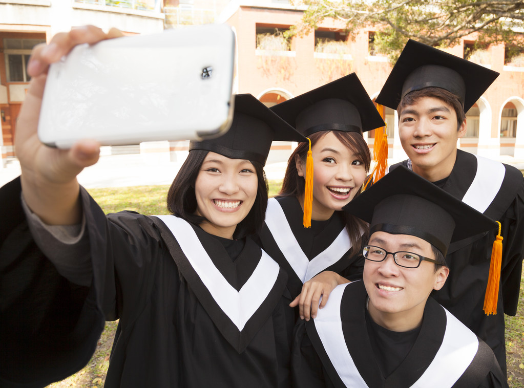 群用手机拍照的大学毕业生图片