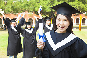 拿着文凭与朋友的快乐的大学毕业生