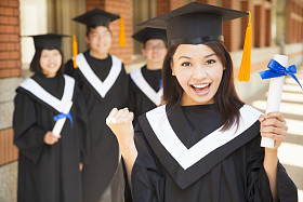 快乐的大学毕业生持有文凭和使一个拳头