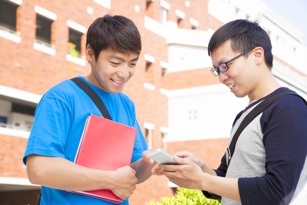 使用一部手机,讨论的两个学生 使用一部手机,讨论的两个学生
