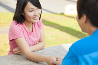 對年輕的夫婦坐在一起，手牽著手