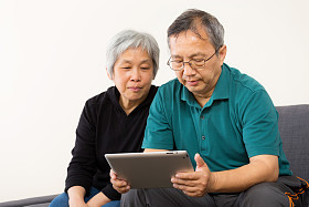 亚洲夫妇在家里使用平板电脑