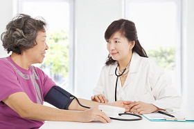 医生测量血压的高级女子在家图片