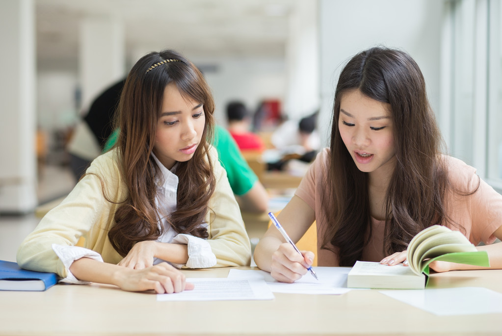 亚洲学生在图书馆工作.图片