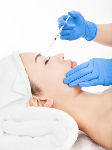 美麗的女人變得注射在她的臉上