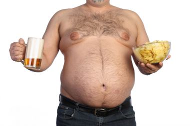 胖男人拿着啤酒、 芯片和电视远程