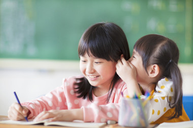 兩個年輕女孩耳語和分享的秘密