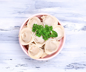 肉馅饺子-俄罗斯煮水饺木制的桌子上