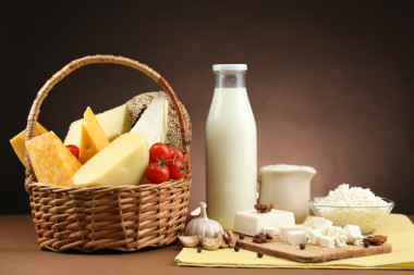 裝著美味的乳制品產(chǎn)品，木制的桌子，暗棕色背景上的籃子