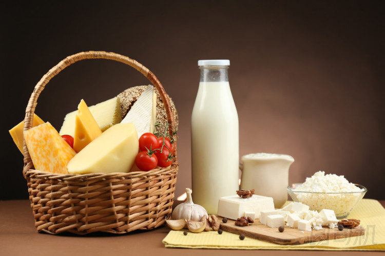 裝著美味的乳制品產(chǎn)品，木制的桌子，暗棕色背景上的籃子