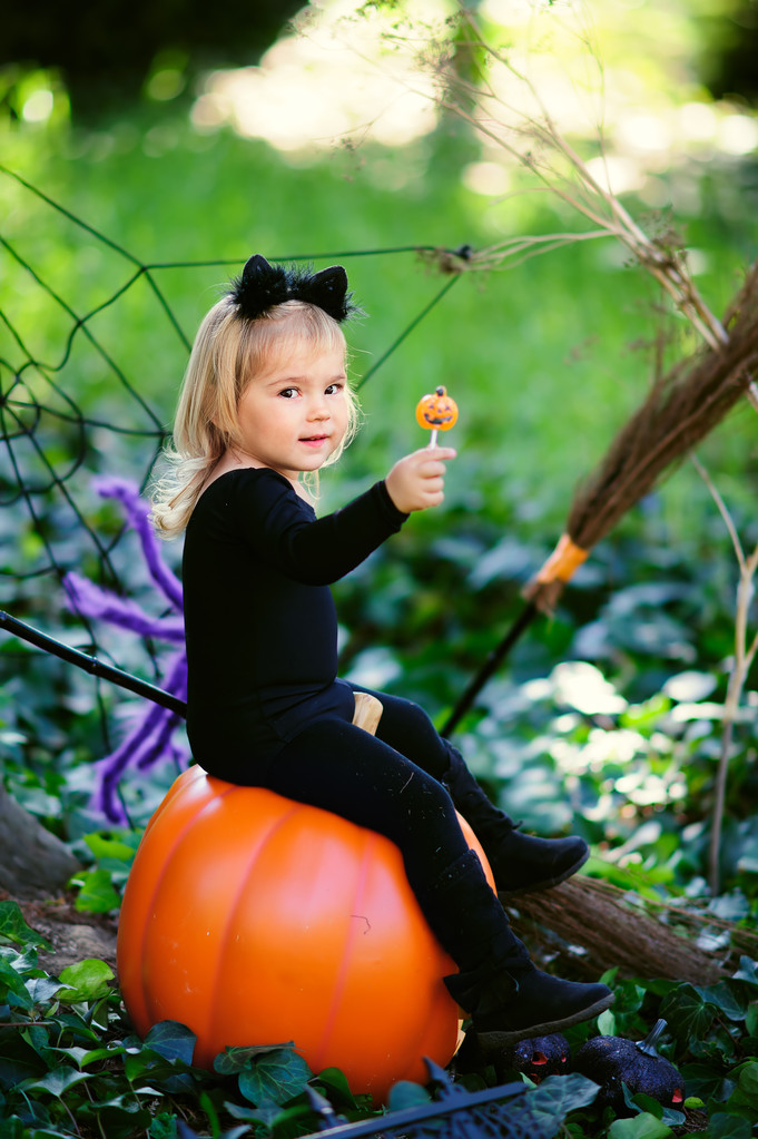 小女孩在万圣节服装与糖果和杰克南瓜 小女孩在万圣节服装与糖果和杰克南瓜