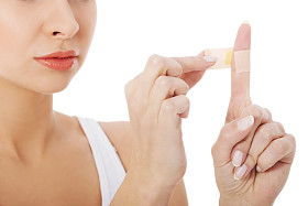 女人她的手指上把胶带.图片