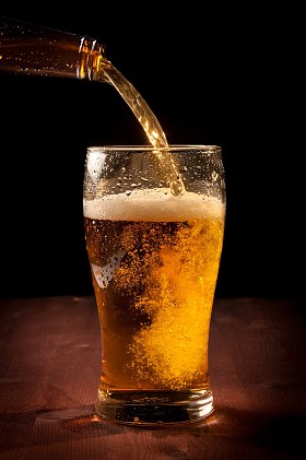 鲜啤酒从瓶涌入玻璃图片