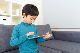 亚洲小男孩专注于使用平板电脑