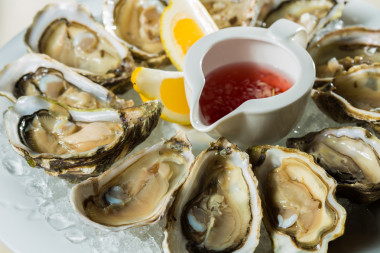 一盤新鮮有機(jī)生蠔在冰上