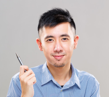 亞洲年輕男子手握一支筆照片