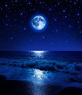 在满天星斗的天空，在海滩上的超级月亮