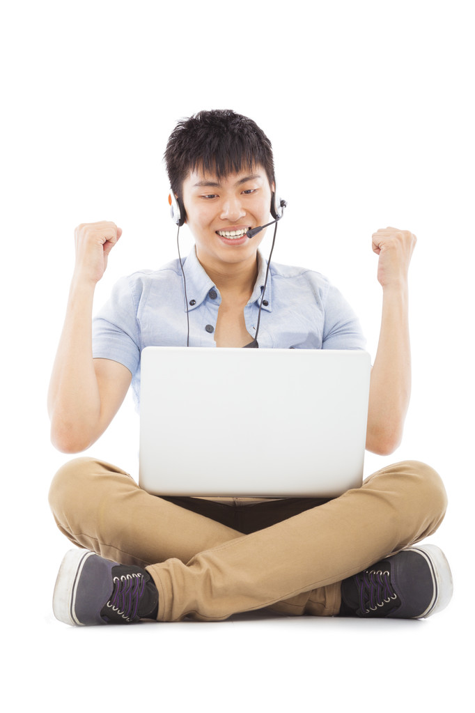 兴奋的年轻男子坐在地板上和学习 兴奋的年轻男子坐在地板上和学习