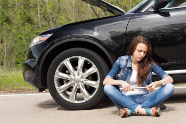 女人在等她壞了的車旁邊圖片