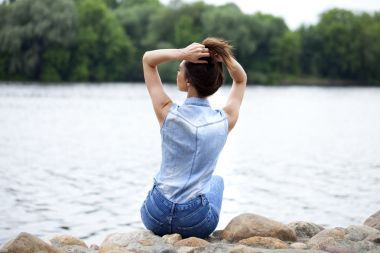 悲傷的女人坐在石頭上圖片