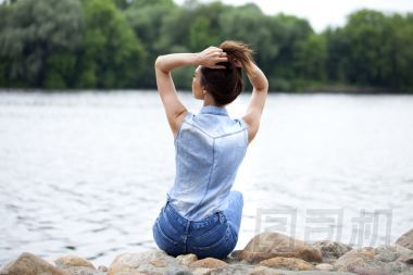 悲傷的女人坐在石頭上圖片