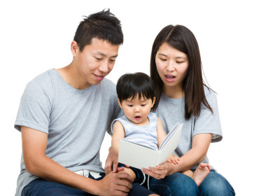 對年輕的夫婦看書的男嬰圖片