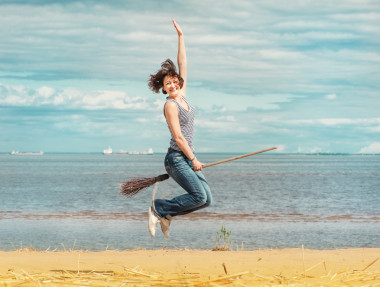幸福的女人，用掃帚在沙灘上跳躍