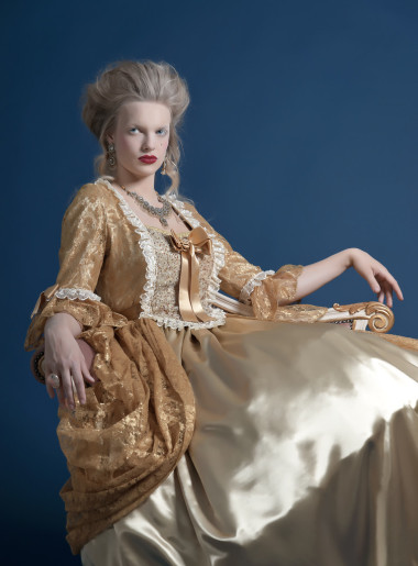 复古的巴洛克式时尚女人穿着金色衣服。坐在文塔