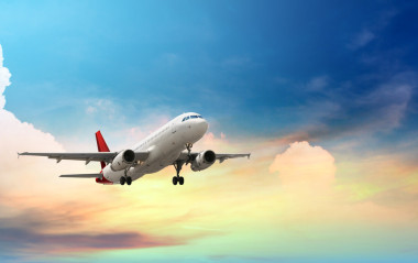 在日落時熱帶海洋上空飛行的飛機