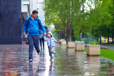 快樂的父親和兒子在雨下運行圖片