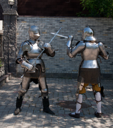 兩個騎士在古代的金屬盔甲，站附近的石墻上