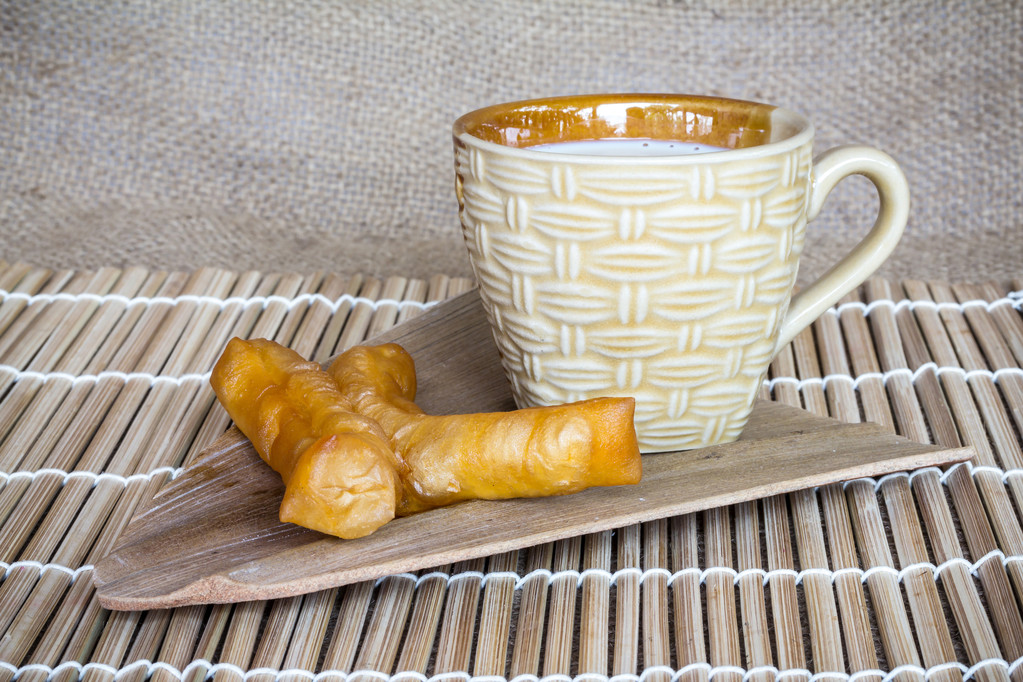 深的油条和一杯豆浆托盘上 深的油条和一杯豆浆托盘上