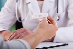 在医生办公室的妊娠实验阳性的女性双手