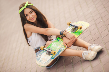 美丽、 时尚的年轻女子假扮与滑板