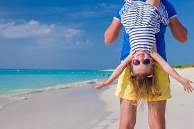 快乐的父亲和他的小可爱女孩在完美的海滩享受暑假