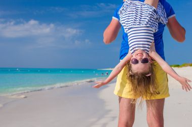 快乐的父亲和他的小可爱女孩在完美的海滩享受暑假