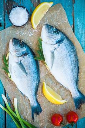 两种原料多拉达海岸鱼与柠檬、 葱和樱桃番茄