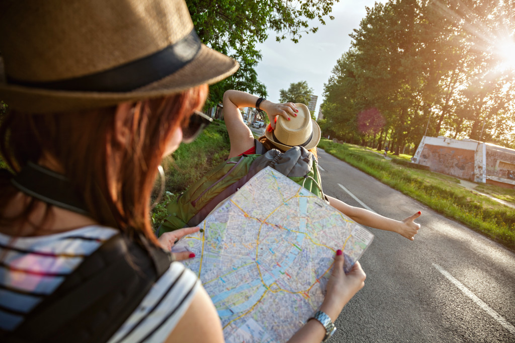 在公路上搭便车的旅游女孩图片